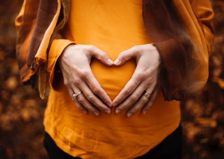 беременная женщина держит живот