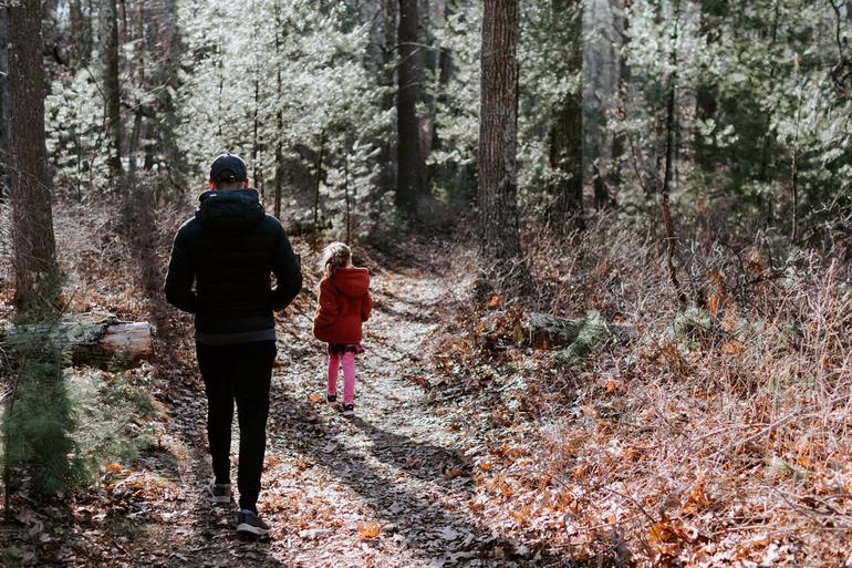 Мужчина и ребенок гуляют в лесу