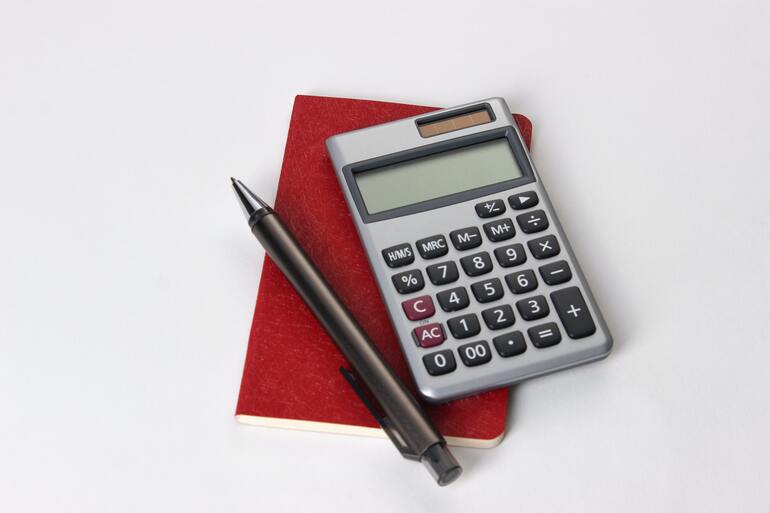 Калькулятор на блокноте рядом с ручкой