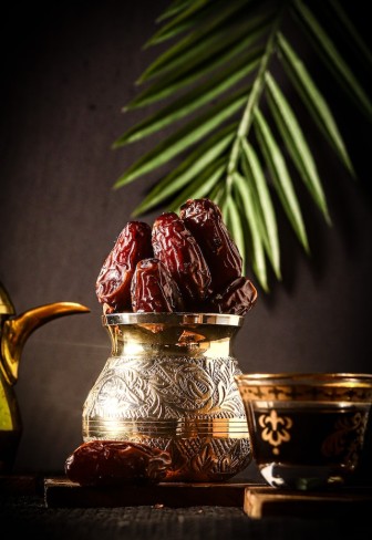 финики возле металлического горшка в арабском стиле
