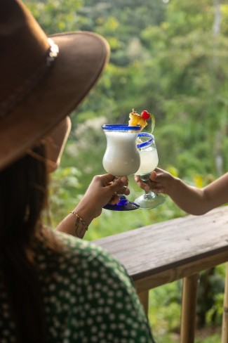 women clinking a glass of Piña Colada on the balcony on vacation